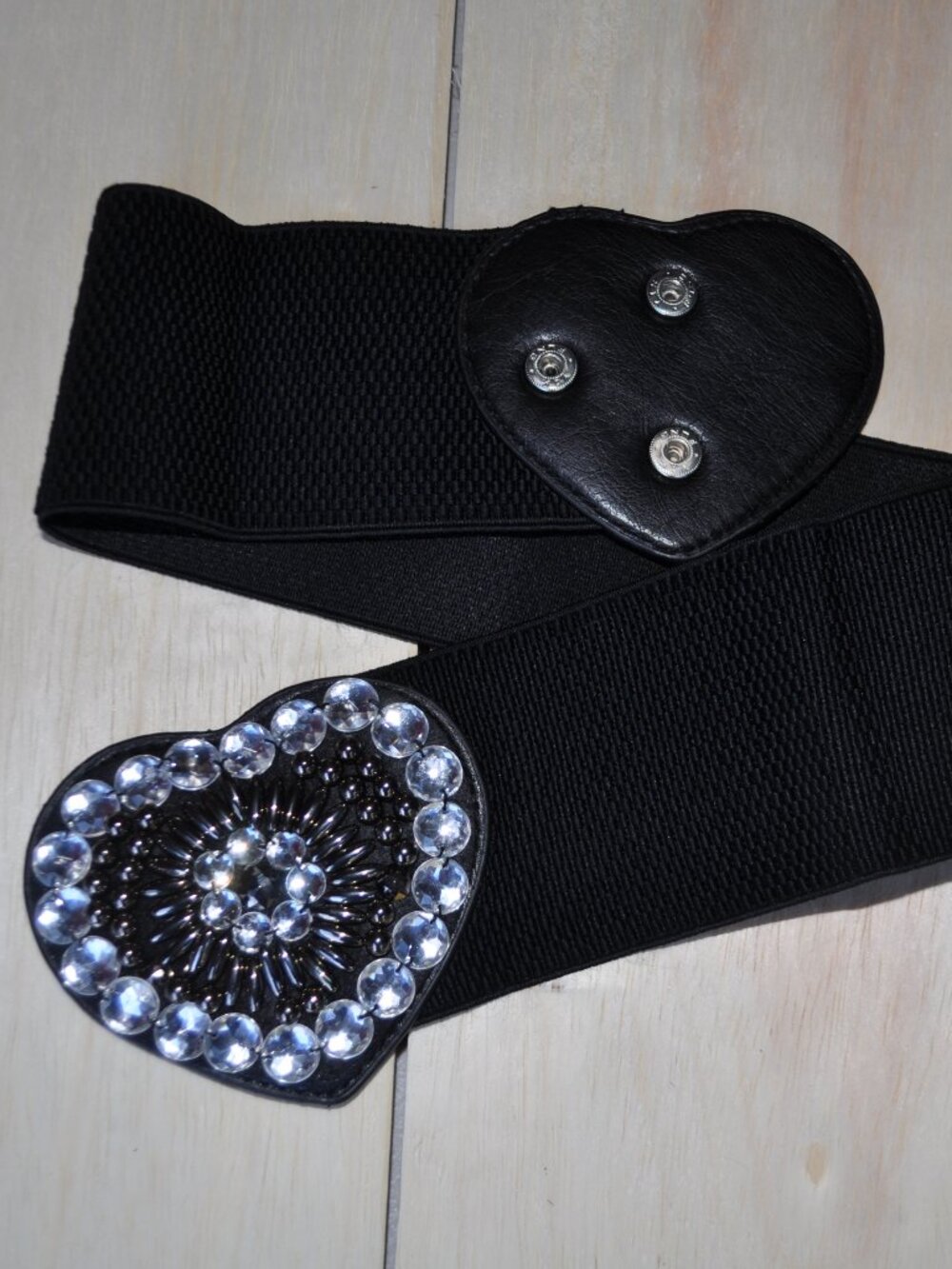 women's black elastic waistband belt features a distinct faux leather heart-shap